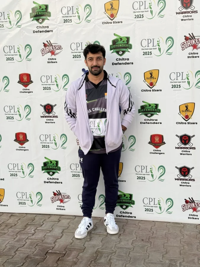 A player in a white jacket in front of the sponsor wall