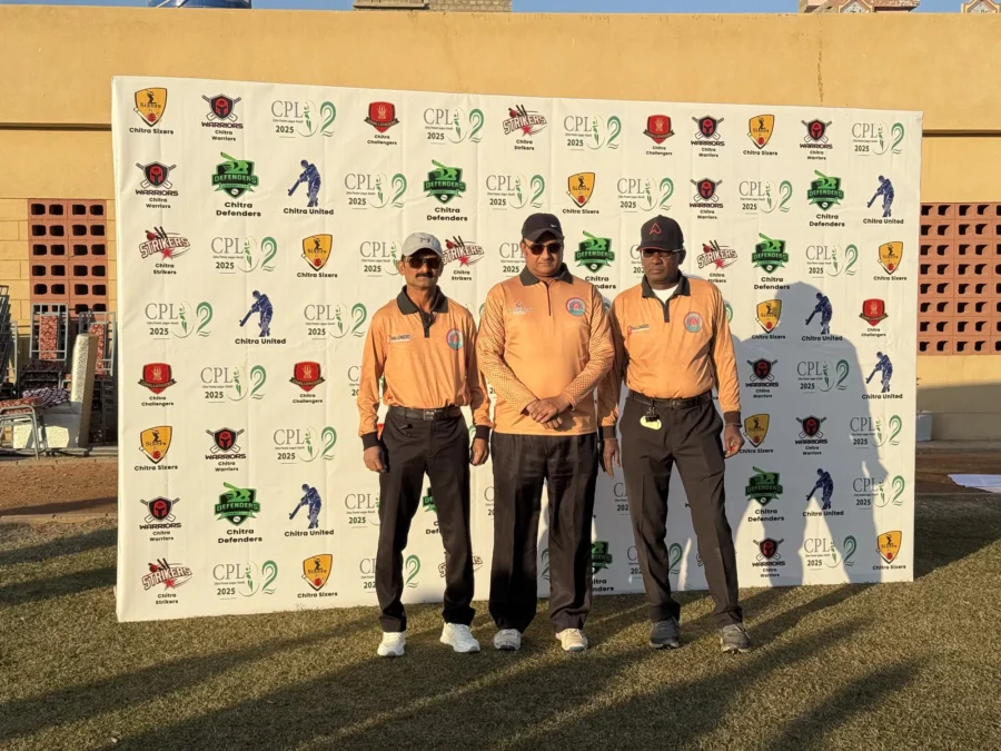 Officials in orange shirts in front of the CPL sponsor wall